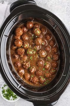 slow cooker filled with meatballs and gravy in a crock pot