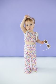 Bask in summer's warmth with our Ray of Sunshine Dream Smocked Flare Set. Made from bamboo material, this smocked flare set is not only comfortable, but also environmentally friendly. With a playful sunglasses print, this outfit is perfect for girls to rock in the summer or spring. Made from theÂ softest and most breathable seasonal bamboo viscose material, your babe won't want to take this off! Designed for all the loveÂ and extra play!Â Our Ray Of Sunshine, Sunglasses Print, First Communion Shoes, Pageant Shoes, Toddler Flower Girls, Girls Gloves, Girls Dress Outfits, Toddler Flower Girl Dresses