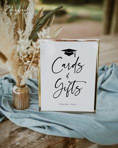 a card and gift box sitting on top of a blue blanket next to a vase filled with flowers