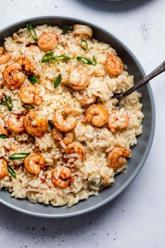 a bowl filled with rice and shrimp on top of a table