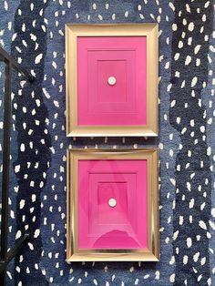 two pink and gold framed pictures on a blue patterned wall with white dots in the background