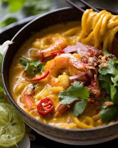 a bowl filled with shrimp and tortilla soup, garnished with cilantro