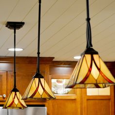 three lights hanging from the ceiling in a kitchen