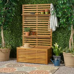 a wooden bench sitting in front of a green wall with potted plants on it