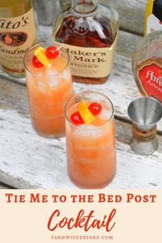 two glasses filled with orange cocktail next to bottles