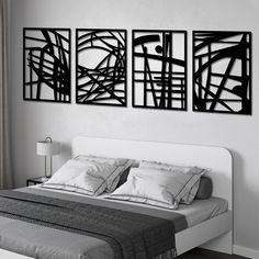 three black and white art pieces hang on the wall above a bed in a bedroom