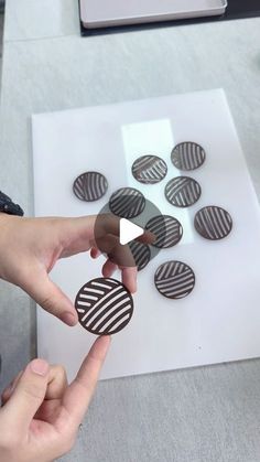 a person pointing at some buttons on a white board with black and white stripes in the middle