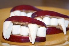 two pieces of fruit with white teeth on them sitting on a yellow plate in the shape of an apple