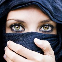 a close up of a person covering their face with a black cloth over her eyes