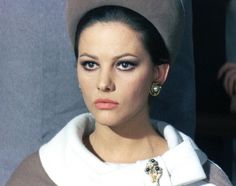 a woman wearing a hat and pearls on her necklace is looking at the camera while posing for a photo