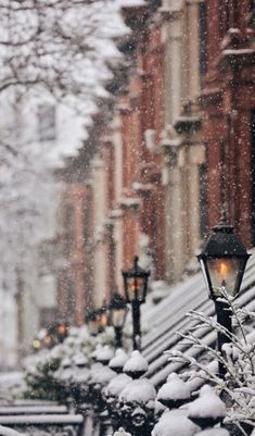 a street light covered in snow next to buildings