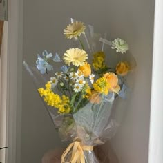 a bouquet of yellow and white flowers sitting on top of a table next to a window