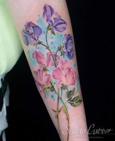 a woman's arm with flowers painted on it