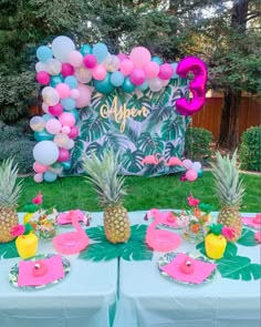 a table topped with pineapples and balloons