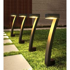 three modern outdoor lights in the grass