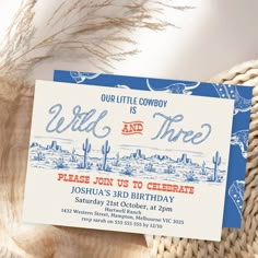 a blue and white birthday card with the words wild time printed on it, sitting next to a wicker basket