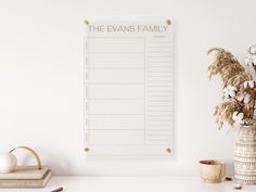 a white board with the words the evans family on it next to a potted plant