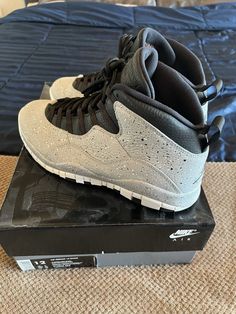 Elevate your sneaker game with these stylish Air Jordan 10 Retro Cement sneakers. Designed for men, these athletic shoes feature a unique blend of gray, light smoke grey, university red, black, and white colors that make them a perfect addition to any wardrobe. The sneakers come in a size 12 and are made of high-quality materials that ensure durability and comfort. The Air Jordan 10 Retro Cement sneakers have a classic cement look and feel that makes them a must-have for any sneaker enthusiast. They are part of the iconic Air Jordan product line and were released in 2018. These sneakers are perfect for casual wear, athletic activities, or simply for adding a touch of style to your outfit. Air Jordan 10, Jordan 10, Sneaker Games, Gray Light, White Colors, Cement, Air Jordan, Air Jordans, Athletic Shoes