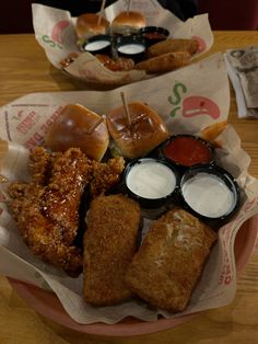 two baskets filled with different types of food on top of a wooden table next to each other