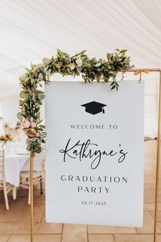 a welcome sign for a graduation party with greenery on top and the words congratulations written in black