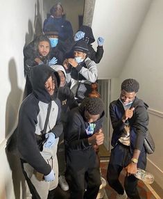 a group of people standing on top of a stair case wearing face masks and gloves