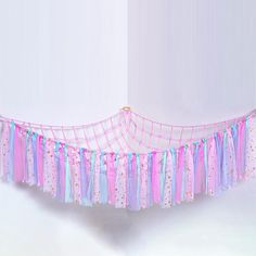 a pink and blue baby crib with streamers hanging from it's sides