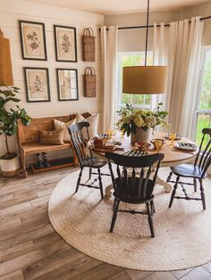 a dining room table with four chairs and a rug on the floor in front of it