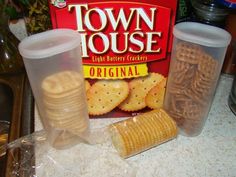 two plastic containers filled with crackers next to a box of town house light butter crackers