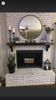 a white brick fireplace with a mirror above it