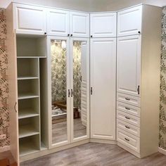 a closet with mirrored doors and drawers in the middle of it, next to a wallpapered wall