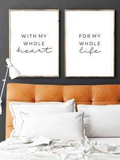 two posters on the wall above a bed with pillows and blankets, one is saying i belong