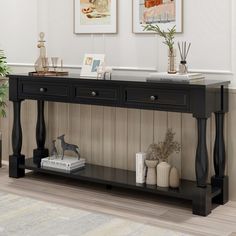 a black console table with three drawers and two vases on the shelf next to it