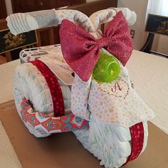 a stuffed animal sitting on top of a cardboard box with a bow around it's neck