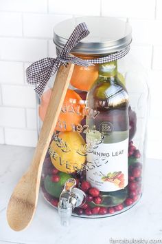 a jar filled with lots of different types of food and a wooden spoon sitting on top of it