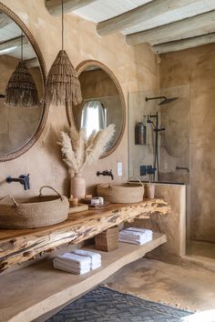 a bathroom with two round mirrors above the sinks and towels on the counter next to it