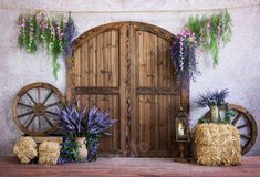 an old wooden door with purple flowers and hay bales on the floor next to it