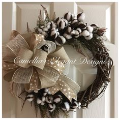 a wreath is hanging on the front door with cotton and burlucks around it