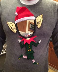 a man wearing a christmas sweater with an elf hat