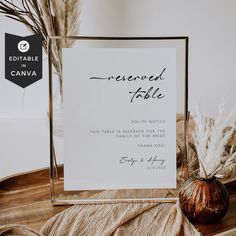 a sign that is on top of a table next to a vase with dry grass