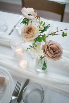 the table is set with flowers and candles