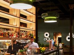 two people behind the bar at a restaurant