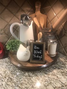 a kitchen counter with a sign that says be kind today and various cooking utensils