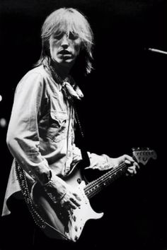 a black and white photo of a man playing an electric guitar