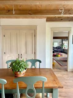 a dining room table with chairs and a potted plant