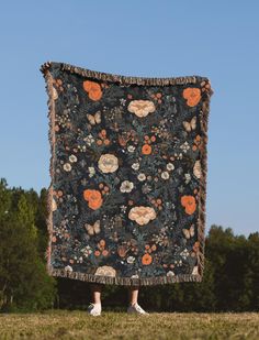 a person standing in front of a large blanket on top of a grass covered field