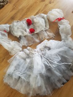 two plastic bags filled with white and red items on top of a wooden floor next to a cat