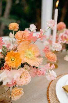 a vase filled with flowers sitting on top of a table next to a white plate