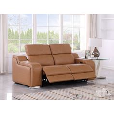 a brown reclining sofa sitting on top of a rug in front of a window