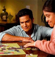 two people sitting at a table playing a board game