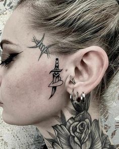 a woman with tattoos on her neck and behind the ear